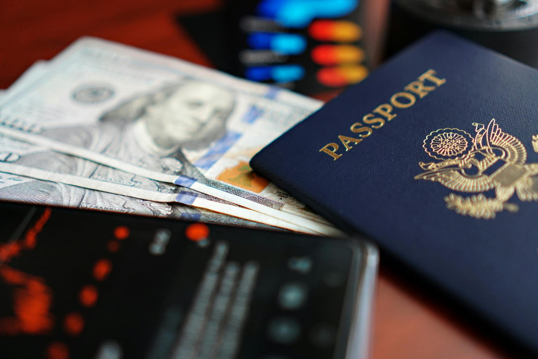 A close-up image of a U.S. passport, dollar bills, and a smartphone. on Points and Pathways