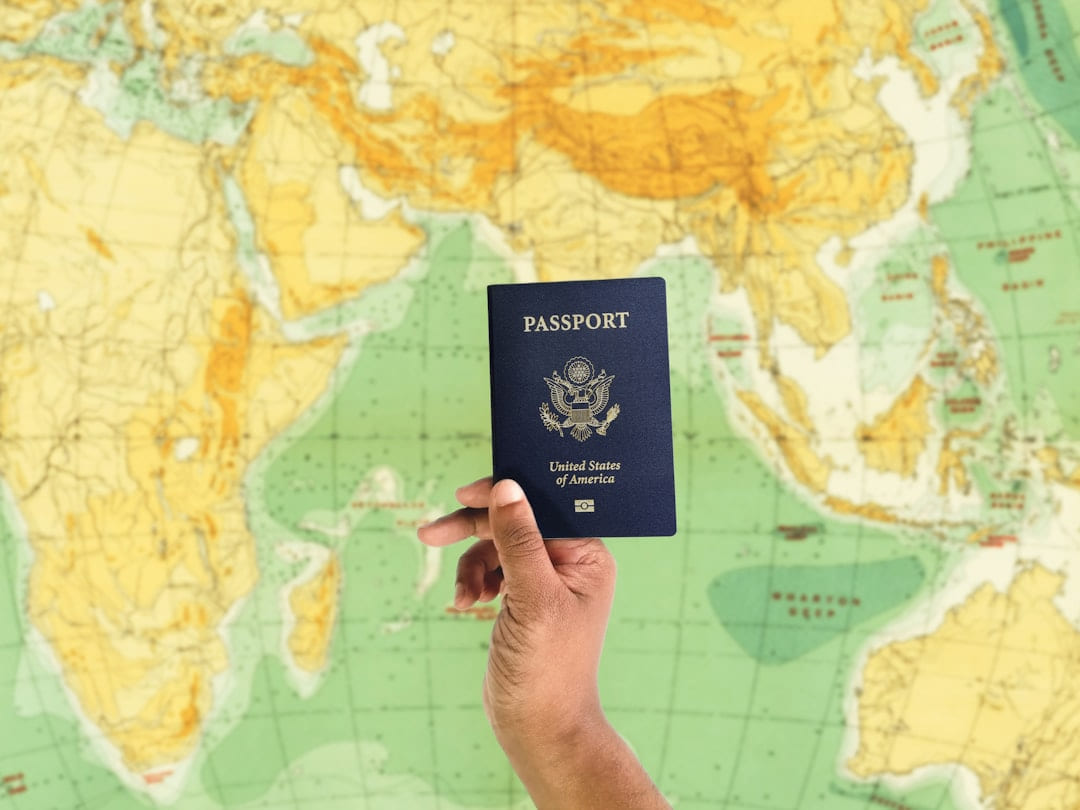 a hand holding a passport over a map on Points and Pathways