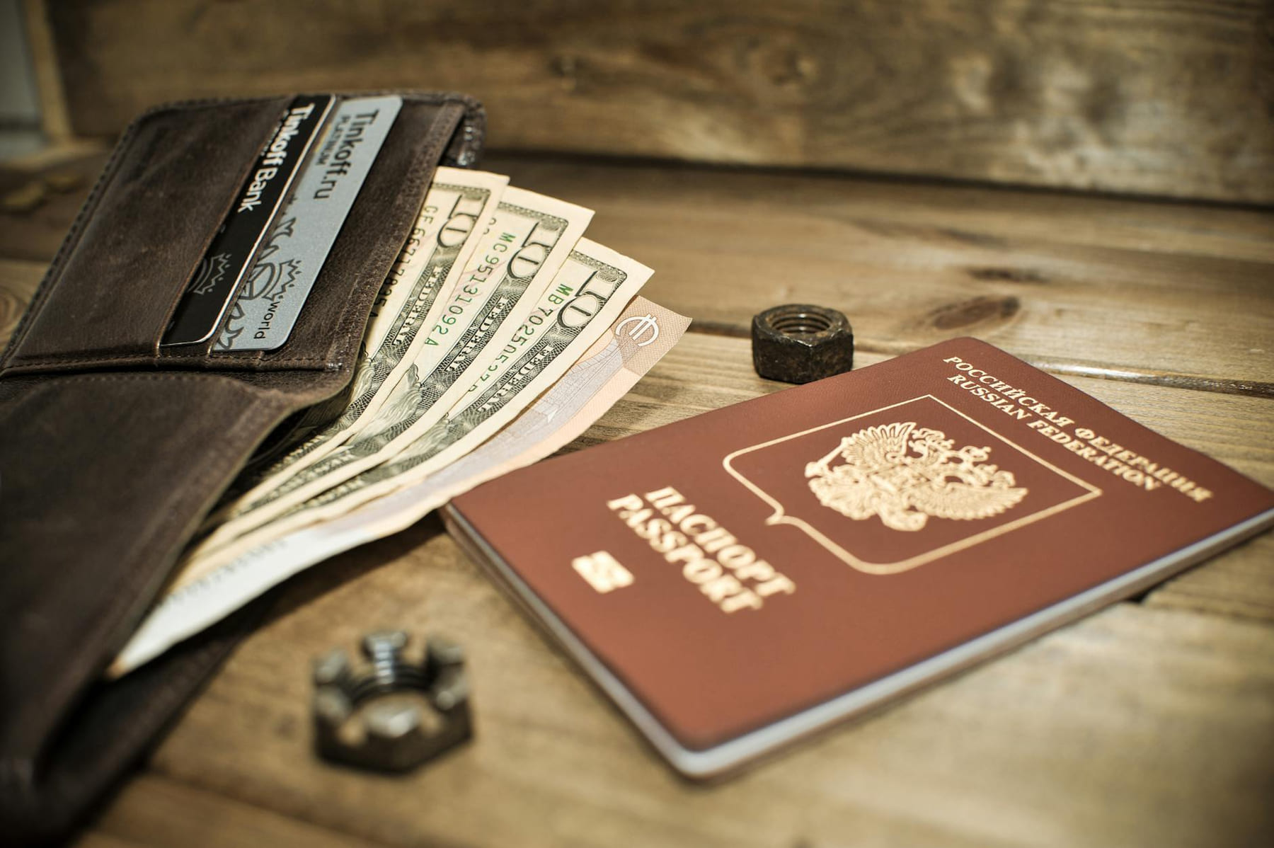 A wallet with cash, credit cards, and a Russian passport on a wooden table. on Points and Pathways