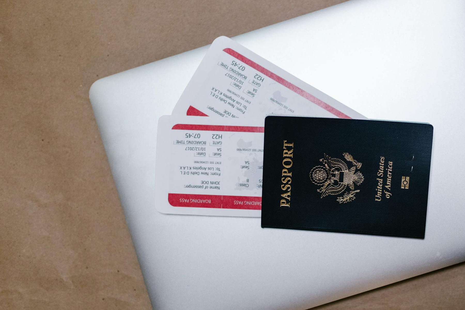 Close-up of a passport and boarding passes on a laptop, symbolizing travel preparation. on Points and Pathways